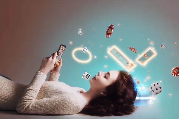 A young woman relaxing with her phone while dynamic casino elements float around her, illustrating the smooth mobile experience offered by the WA777 app.
