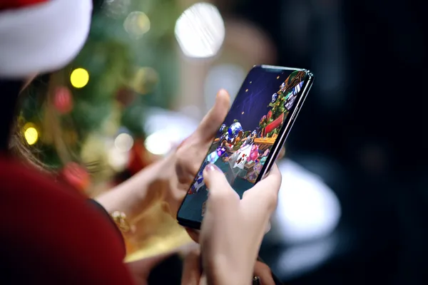 A player using their smartphone during a festive local event, representing WA777’s fully mobile-friendly casino.